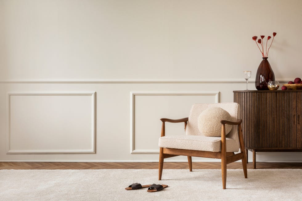 composition esthétique de l'intérieur du salon avec espace de copie, fauteuil boucle, vase avec fleurs séchées, oreiller rond, buffet en bois, tapis beige et accessoires personnels modèle de décoration intérieure