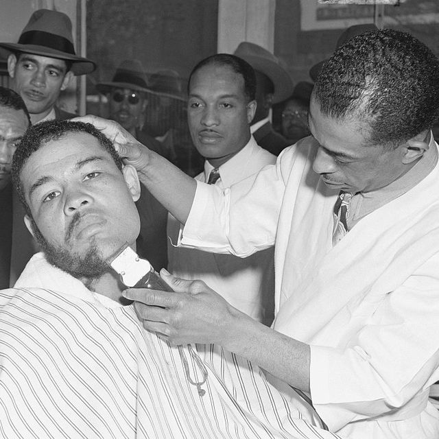 heavyweight champion joe louis gets a nice growth of beard shorn off with an electric razor in the capable hands of his old friend william herring joe hit new york today, beard and all, from indiana, to conclude his training at pomton lakes, nj, for his forthcoming bout with billy conn, june 19th