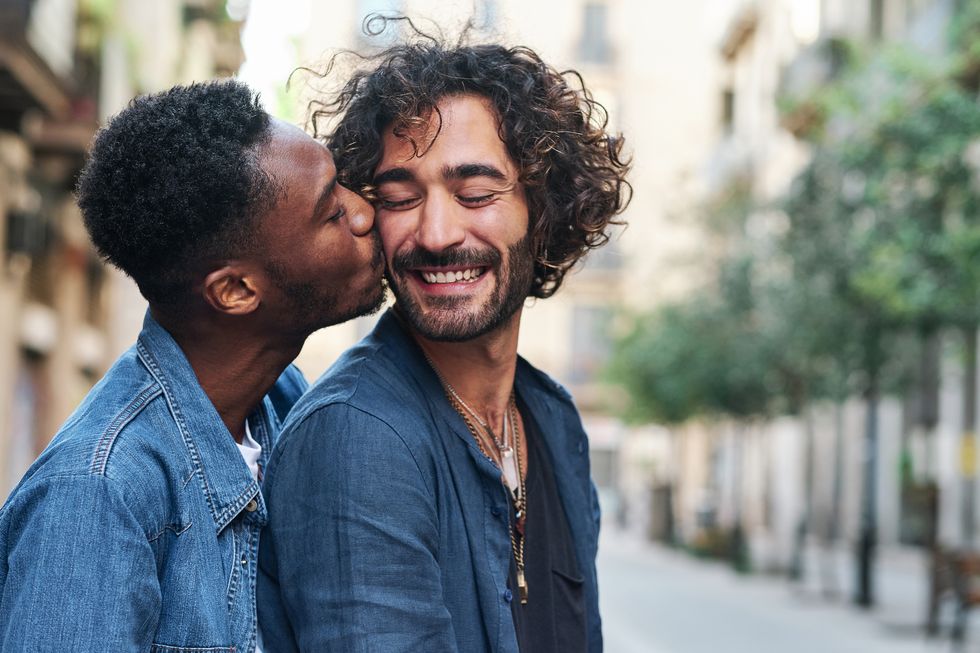 affectionate gay man kissing happy boyfriend