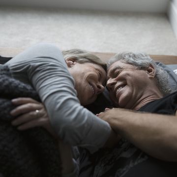 Affectionate, romantic senior couple cuddling in bed