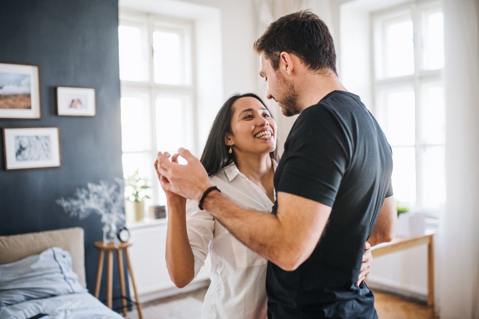 affectionate young couple in love dancing at home, having fun