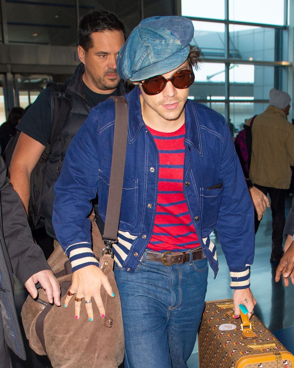 11182019 exclusive a very fashionable harry styles arrives at jfk airport in new york city after hosting saturday night live' the 25 year old english singer and actor had his nails painted pink and blue and was carrying mickey mouse luggage styles also wore a denim cap, striped sweater, blue jacket, bell bottom jeans, and white trainers salestheimagedirectcom please bylinetheimagedirectcomexclusive please email salestheimagedirectcom for fees before use