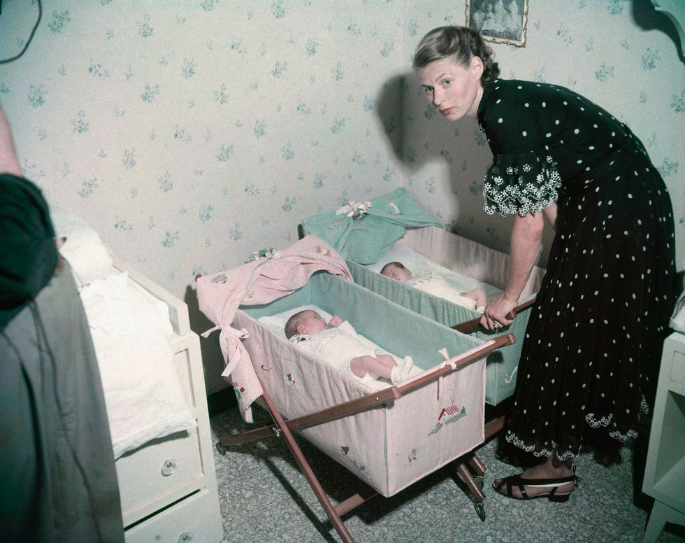 actress ingrid bergman bending over the beds of her twins, left, isotta ingrid and, right, isabella for the first time she presented them to the press at the rossellini’s villa at santa marinella, about 35 miles north of rome on july 9, 1952 ap photomario torrisi