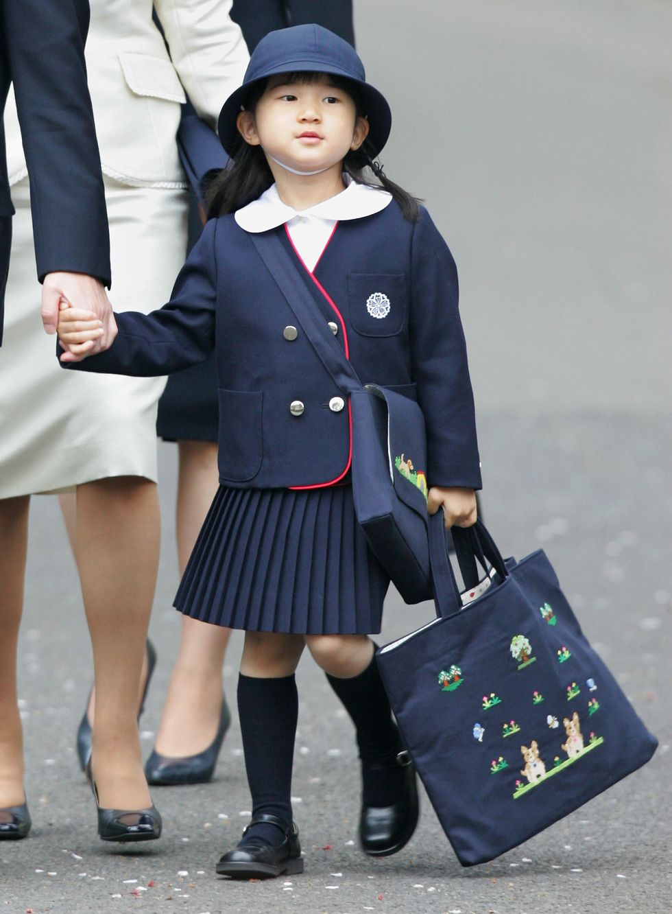 a young girl in a uniform holding an umbrella