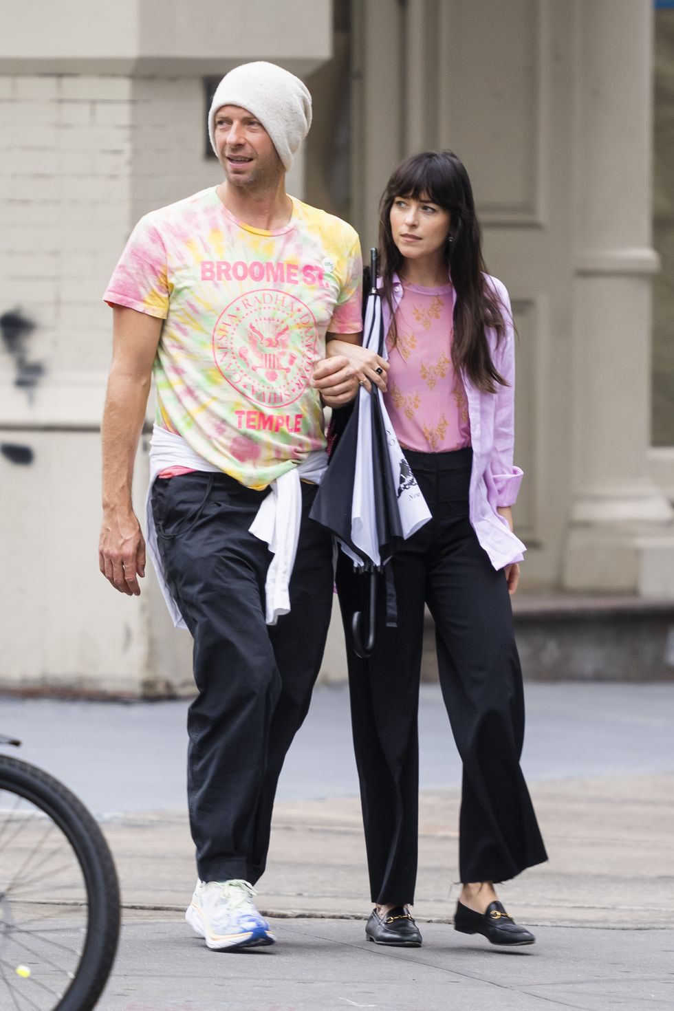 06072022 exclusive chris martin and dakota johnson step out for a stroll in new york city the 45 year old english singer songwriter and his 32 year old actress girlfriend walked through trendy soho arm in arm before they were approached by a fan where chris presented her with a pin that said "love" before the couple continued on keeping close to one anothersalestheimagedirectcom please bylinetheimagedirectcomexclusive please email salestheimagedirectcom for fees before use