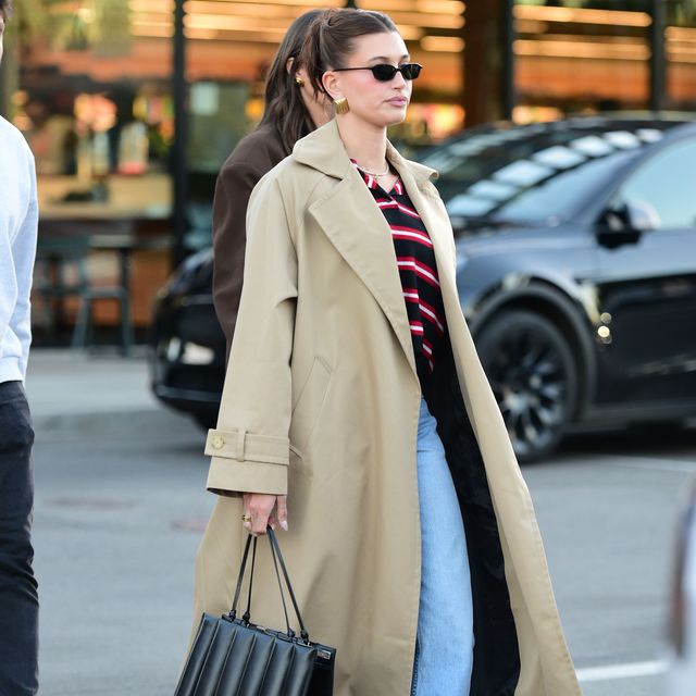 01162024 hailey bieber is spotted exiting erewhon market in los angeles the 27 year old american model wore a long beige trench coat over a blue and red sweater paired with distressed denim jeans and redleather loaferssalestheimagedirectcom please bylinetheimagedirectcom