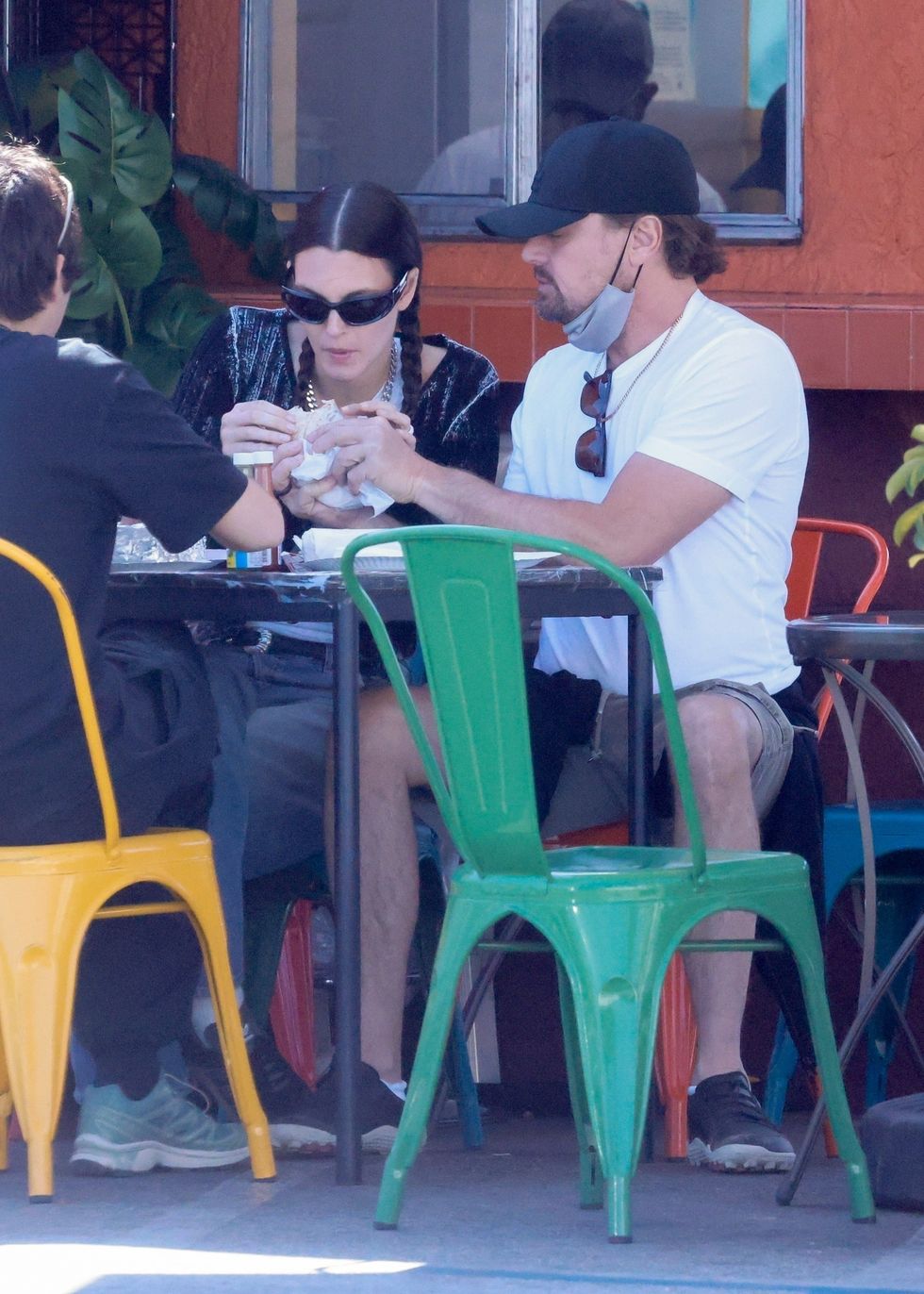 a man and woman sitting at a table eating food