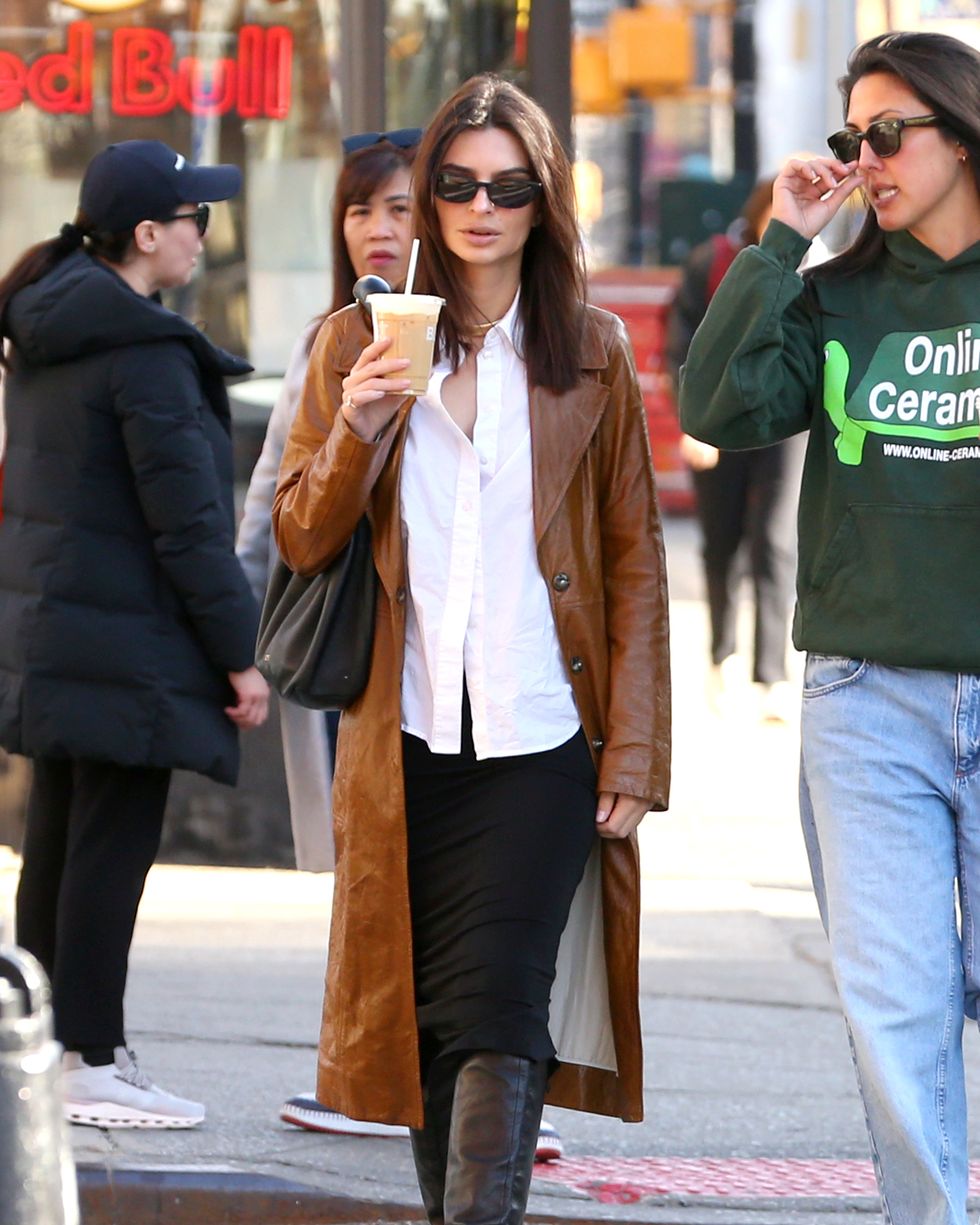a person in a trench coat holding a cup of coffee