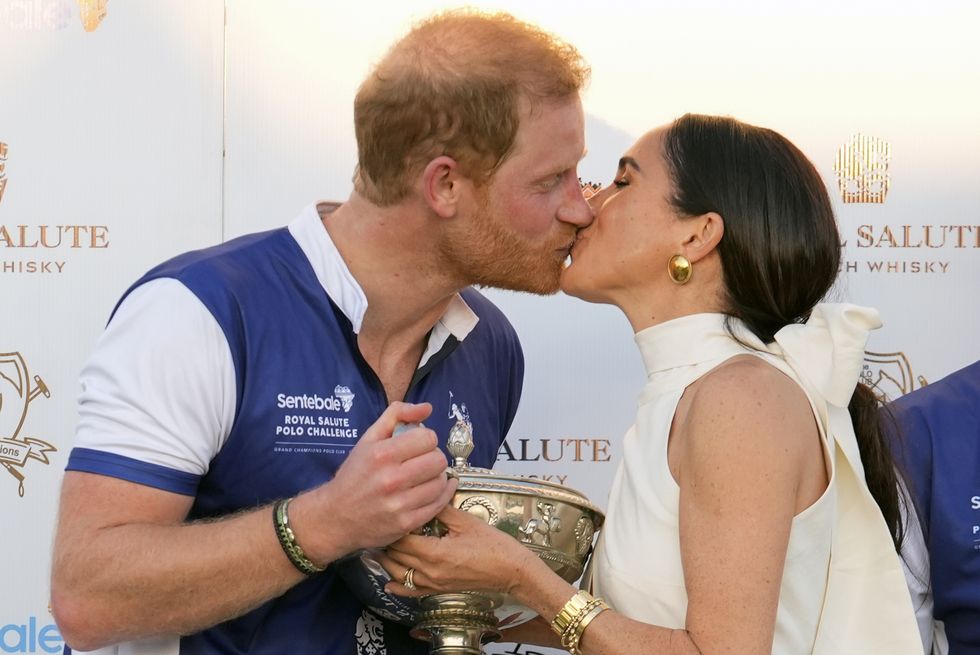 britains prince harry, left, and wife, meghan markle, duchess of sussex, kiss as she presents his polo team with the trophy for winning the royal salute polo challenge to benefit sentebale, friday, april 12, 2024, in wellington, fla prince harry, co founding patron of the sentebale charity, will play on the royal salute sentebale team ap photorebecca blackwell