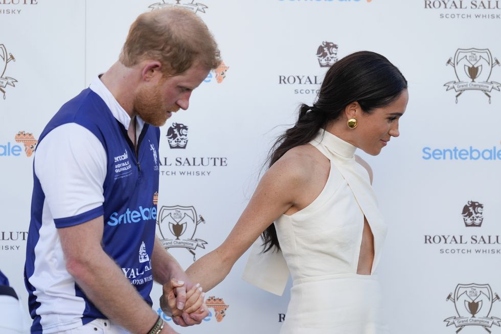 britains prince harry, left, and wife meghan markle, duchess of sussex, hold hands as they leave the stage after the prize ceremony for the 2024 royal salute polo challenge to benefit sentebale, friday, april 12, 2024, in wellington, fla ap photorebecca blackwell