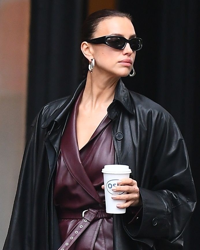 a woman wearing sunglasses and holding a coffee cup