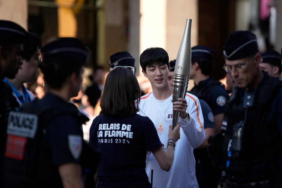 jin, the oldest member of k pop supergroup bts, is given the olympic torch, sunday, july 14, 2024 in paris jin will carry the olympic torch in the area of paris louvre museum after recently completing his mandatory military service ap photolouise delmotte