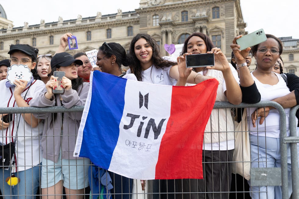 fans wait for the venue of the bts singer kim seok jin during the olympic torch relay in front of the louvre pyramid, designed by chinese us architect ieoh ming pei, in paris on july 14, 2024, ahead of the upcoming paris 2024 olympic games photo by raphael lafargueabacapresscom