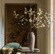 cream colored blossoms in a tall vase