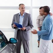 african american father and son discussing with a car salesperson