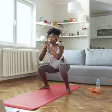 african american female in sportswear is doing squat