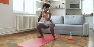african american female in sportswear is doing squat