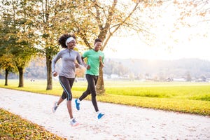 african american friends running together in nature