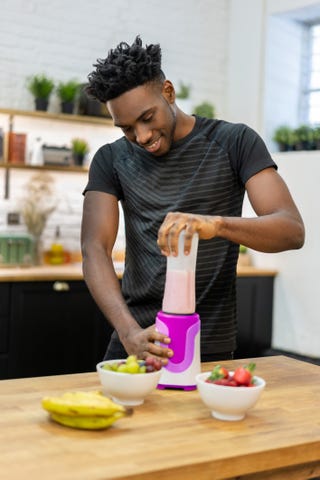 african american man at home making a healthy smoothie