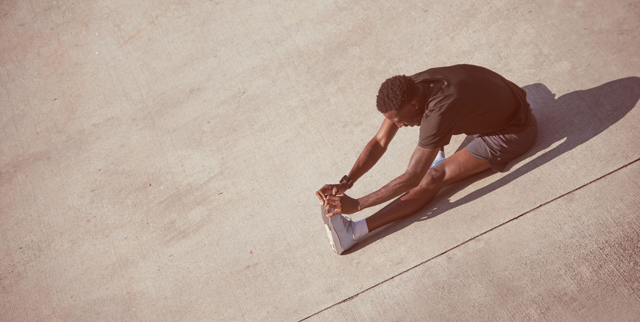 African American man stretches on pavement