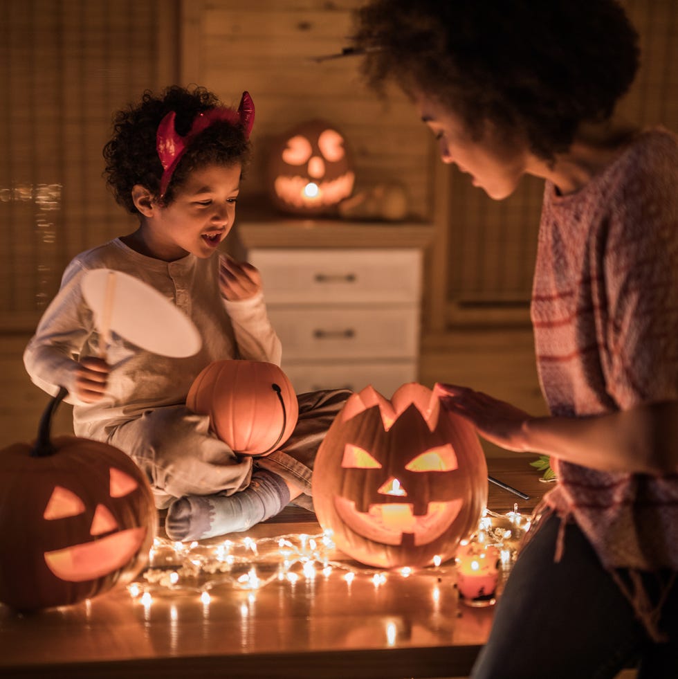 halloween trivia mom and daughter putting lights inside a jack o lantern