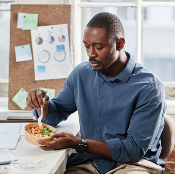 african american office worker having salad for lunch