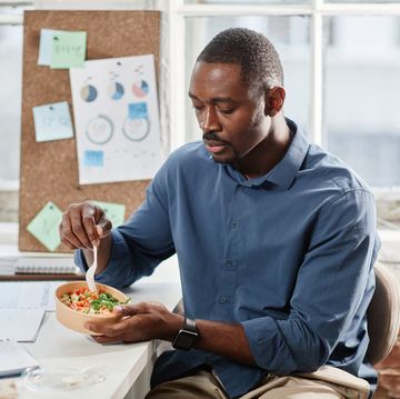 african american office worker having salad for lunch