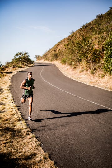 african american runner jogging down a deserted mountain road