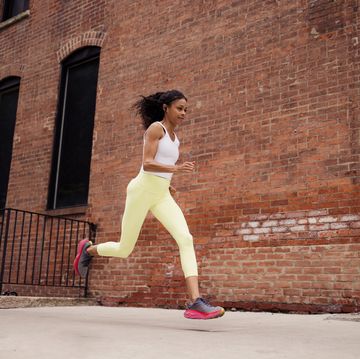 african american sportswoman jogging on the city street.