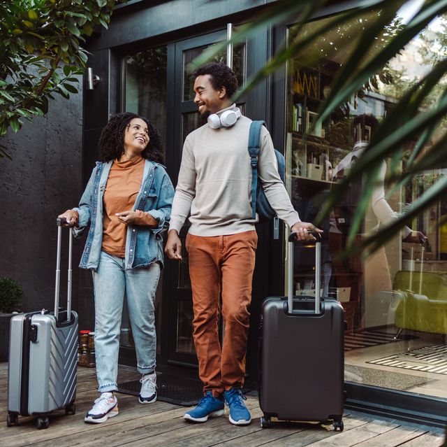 african american tourists with suitcases in front of the rented apartment