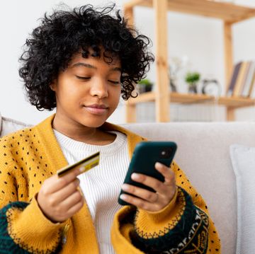 young woman checking visa gift card balance using smartphone