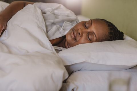 how to look younger african american woman sleeping soundly in her bed at home