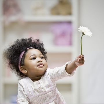 african baby girl holding flower