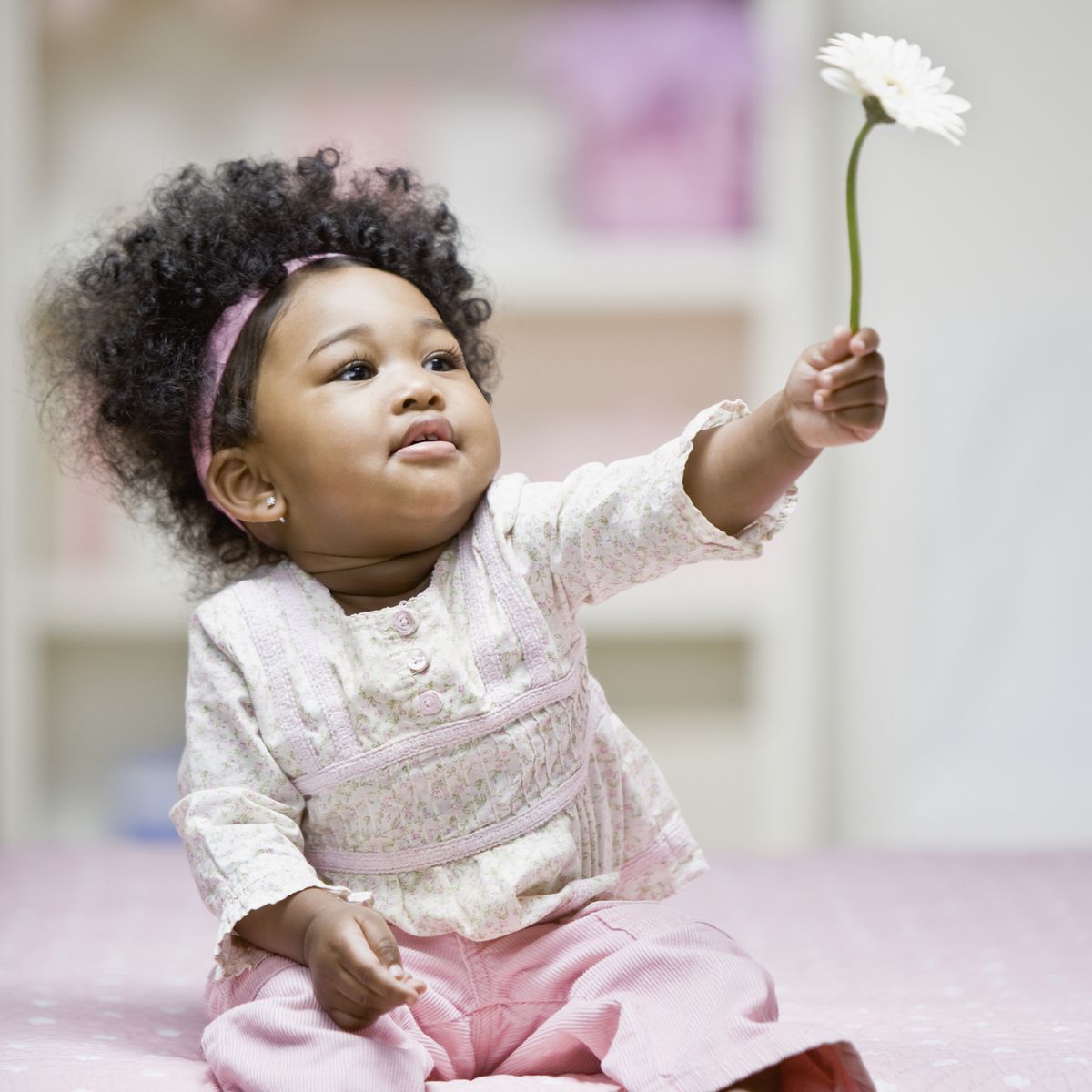 https://hips.hearstapps.com/hmg-prod/images/african-baby-girl-holding-flower-royalty-free-image-1676500153.jpg?crop=1.00xw:0.686xh;0,0.153xh&resize=1200:*