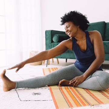 african woman doing stretching at home