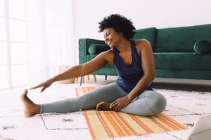 african woman doing stretching at home