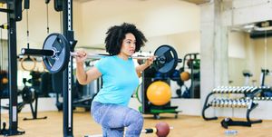 african woman practicing with barbells, running before or after workout