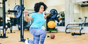 african woman practicing with barbells, running before or after workout