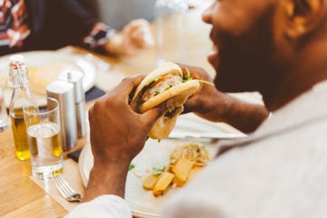 afro american eating burger in a restaurant