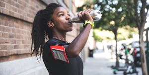 afro american woman with dreadlocks in a great athletic shape working out and training hard outdoors