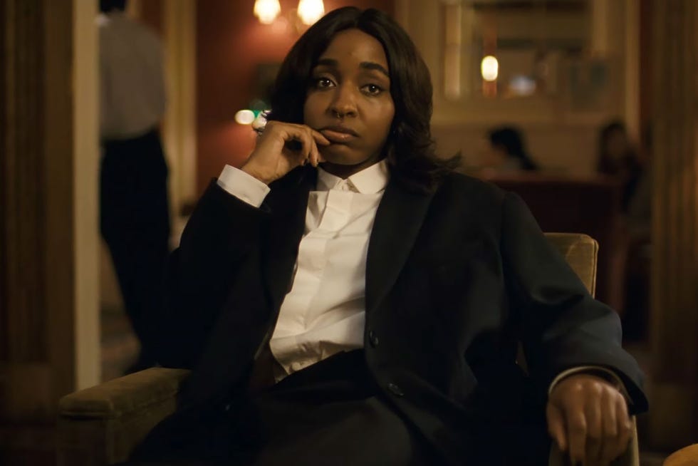 individual seated in a formal setting deep in thought