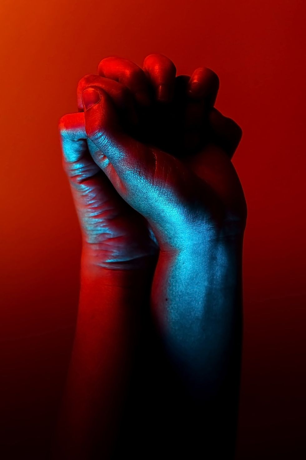 two people holding hands against a red background