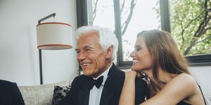 smiling young woman with elegant senior man on couch