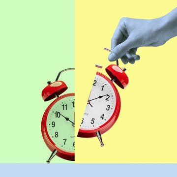 Splitting time in half black and white young womans hand holding half of split alarm clock on illustrated green yellow and blue background