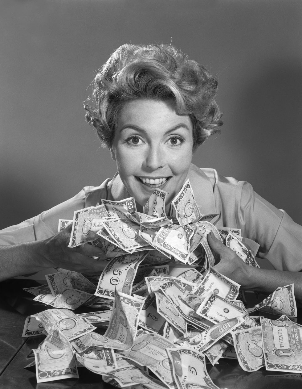 mujer sonriente con una pila de billetes