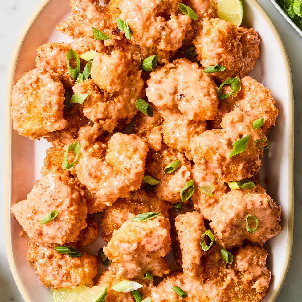 fried shrimp tossed in sauce and garnished with green onions