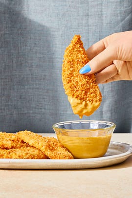 breaded chicken strips dipped in yellow sauce