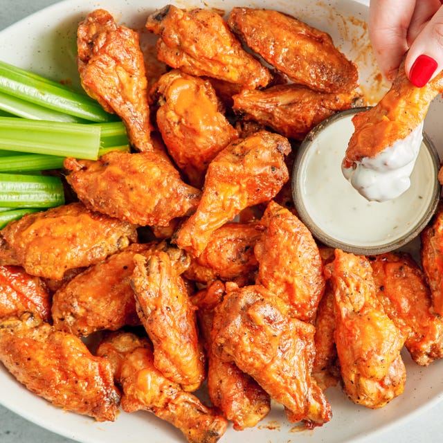 air fryer chicken wings covered in buffalo sauce with blue cheese and celery