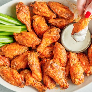 air fryer chicken wings covered in buffalo sauce with blue cheese and celery