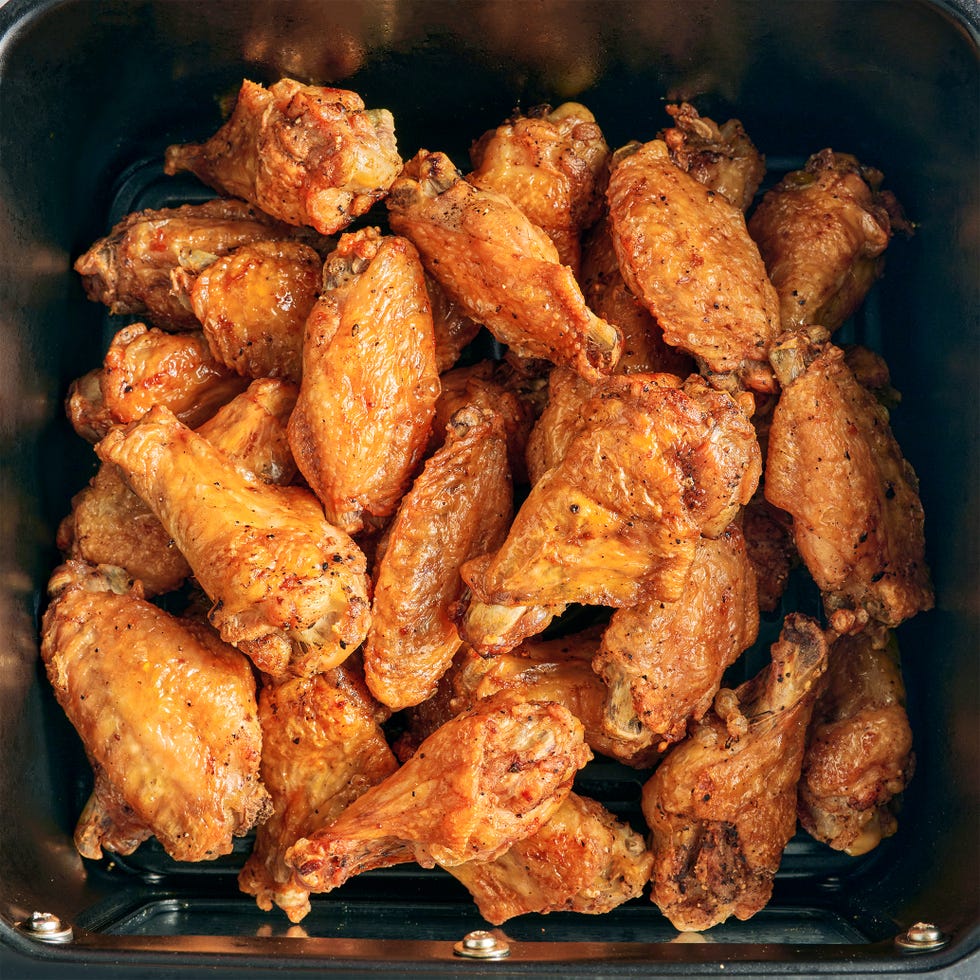 air fryer chicken wings covered in buffalo sauce with blue cheese and celery